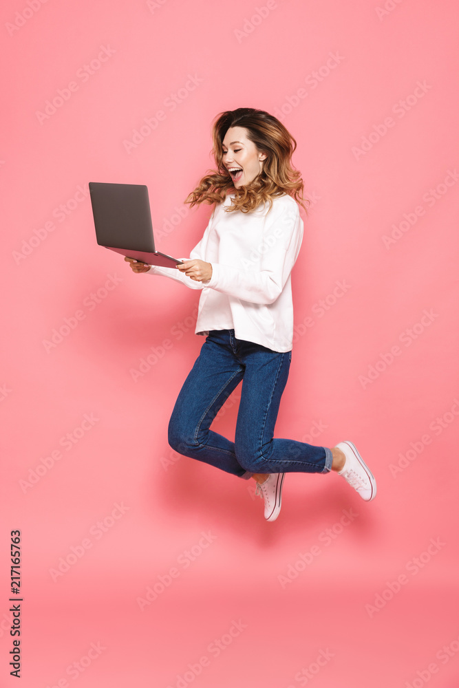 Full length portrait of a happy young woman jumping Full length portrait of a happy young woman jumping