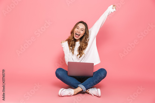 Portrait of a happy young woman sitting with legs crossed