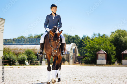 Promising equestrian. Young promising equestrian feeling excited while training on big spacious race track