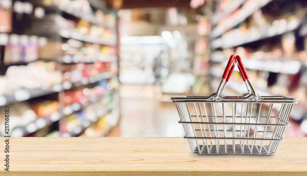 Empty Shopping basket on wood table over grocery store supermarket blur background Empty Shopping basket on wood table over grocery store supermarket blur background