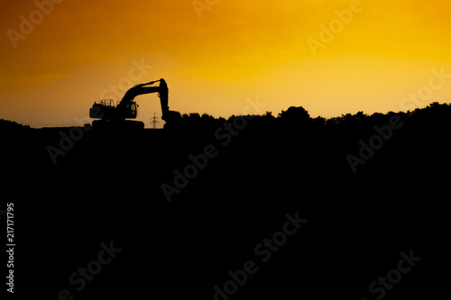 Silhouette of a excavator in the sunset