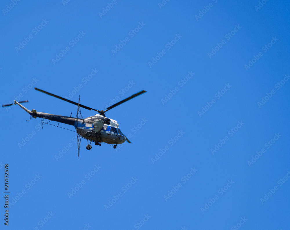 A helicopter of agricultural aviation is flying in the blue sky. A helicopter of agricultural aviation is flying in the blue sky.