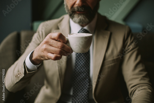 Handsome senior businessman drinking coffee in lobby © BGStock72