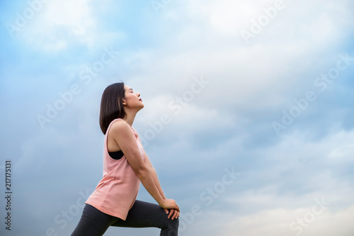 Portrait young sport girl doing stretching and warming up body in park. Healthy and care concept.