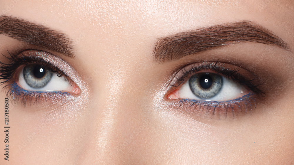 Obraz premium Close-up portrait of sexy young woman with beautiful blue eyes. Woman beauty face portrait with healthy skin. Portrait of beautiful young woman looking at camera. Natural beauty concept