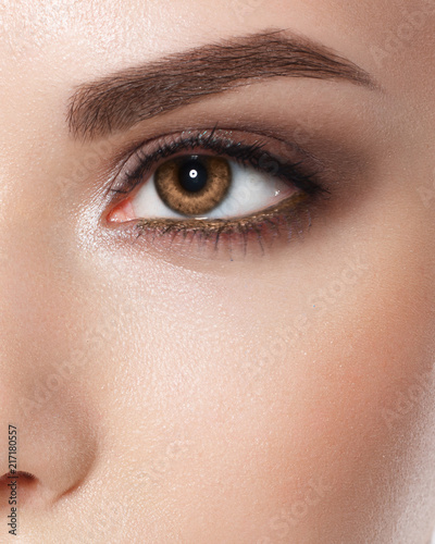 Close up view of beautiful brown female eye. Perfect trendy eyebrow. Good vision, contact lenses, brow bar or fashion eyebrow makeup concept