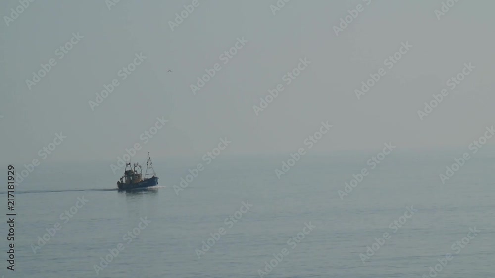 A commercial boat navigating through fog on the open sea. A commercial boat navigating through fog on the open sea.