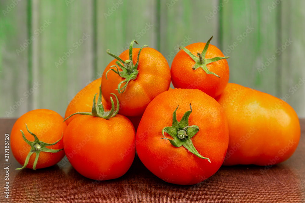 Bunch of tomatoes on the background of a wooden facade Bunch of tomatoes on the background of a wooden facade