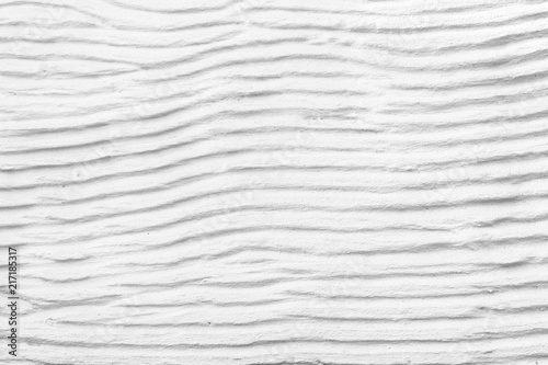 Fototapeta Naklejka Na Ścianę i Meble -  White plaster cement structure with relief curved strips. Background texture of horizontal cement uneven wavy strips