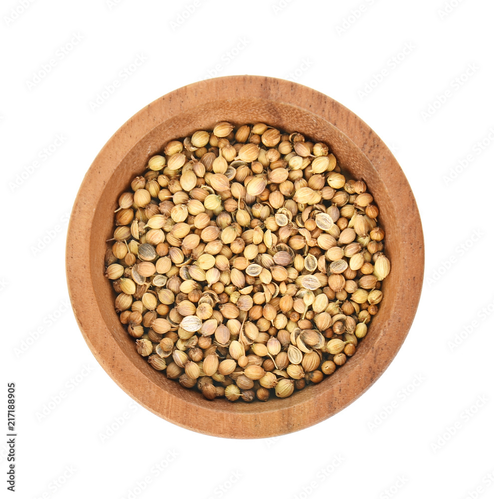 Top view of dried coriander seeds in the wooden plate white background Top view of dried coriander seeds in the wooden plate white background