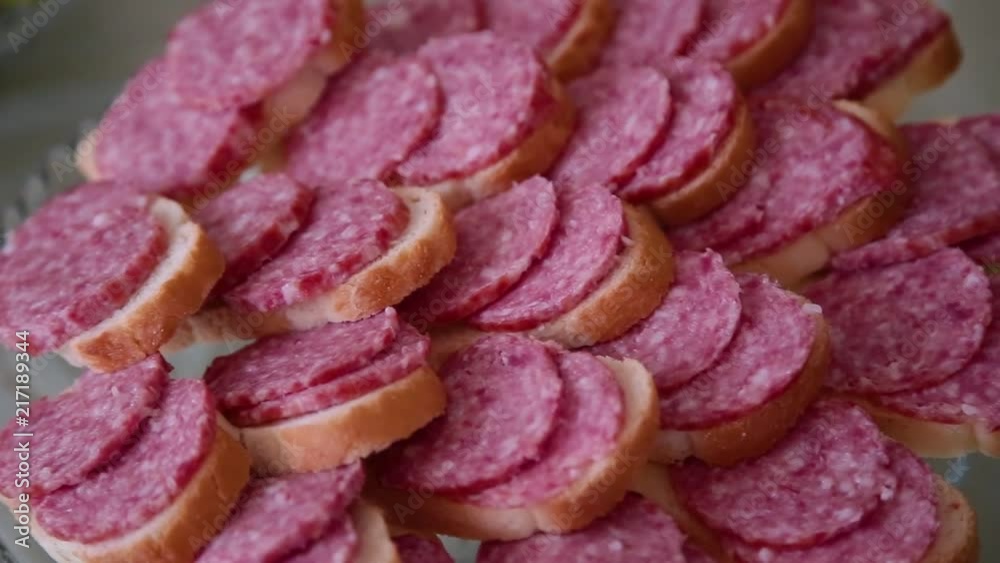 Sandwiches with sausage on a glass plate. Sandwiches with sausage on a glass plate.