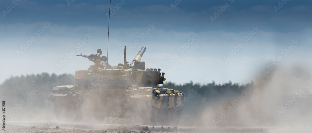 Military or army tank ready to attack and moving over a deserted battle field terrain. a lot of dust. copyspace Military or army tank ready to attack and moving over a deserted battle field terrain. a lot of dust. copyspace