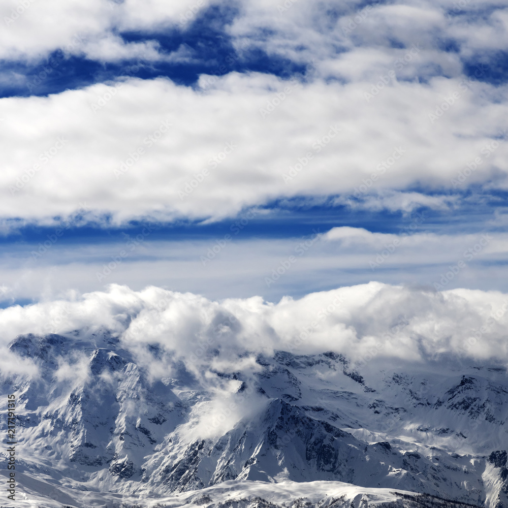 Sunlight snowy mountains in clouds Sunlight snowy mountains in clouds