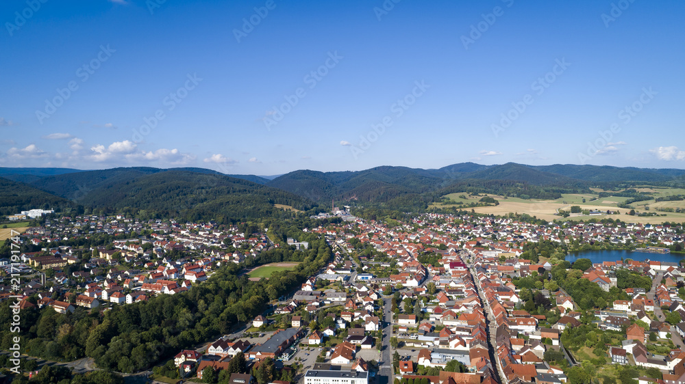 Aerial drone bird's eye view photo european village of central germany with red roofs and cozy streets, morning sun lights