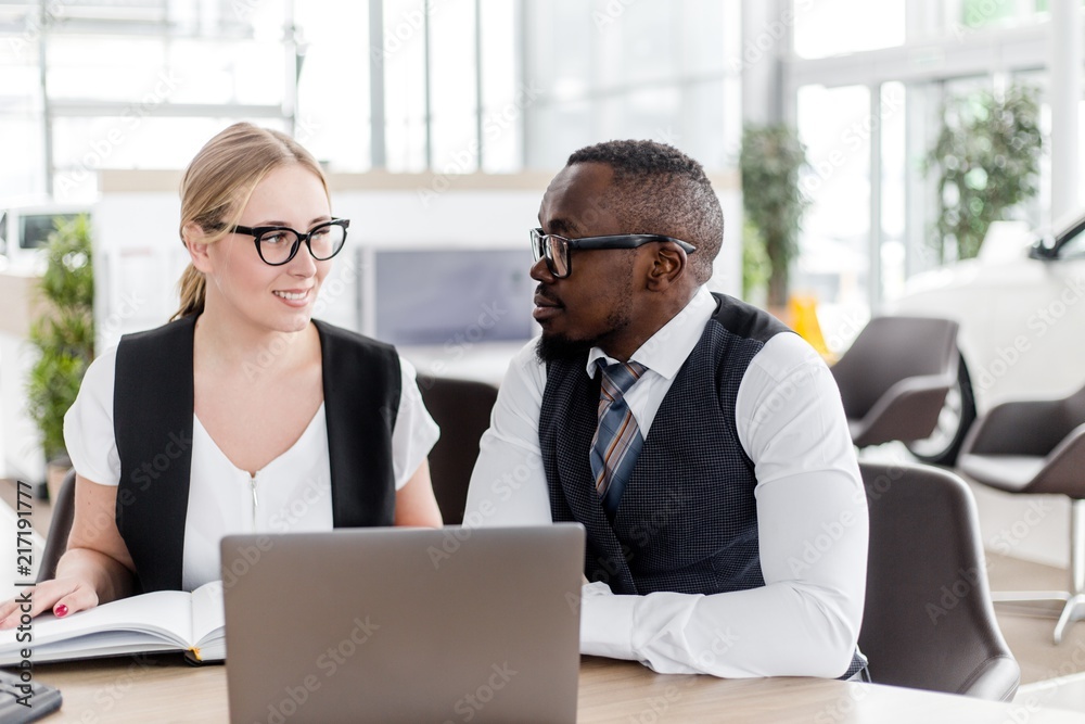 Φωτογραφία Business woman working with African man sitting at table in office