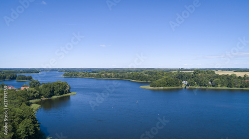 Aerial view of a country side with agricultural fields iand a lake. Beautiful landscape.  Captured from above with a drone