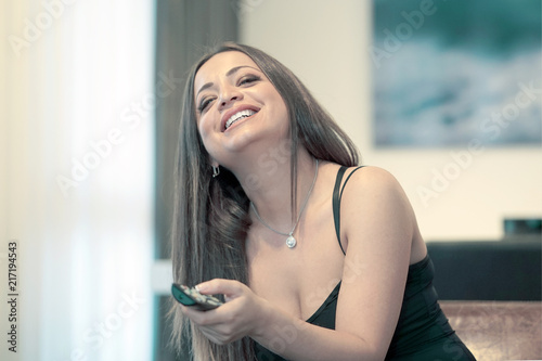 Woman with tv remote control on sofa