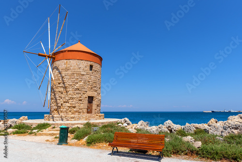 Historic windmill on seaside promenade in Mandrakia port. Rhodes island, Greece