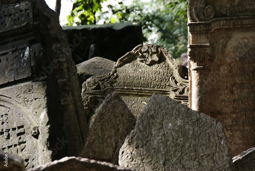 Historic old Jewish cemetery with rock tombs in Prague and broken monuments by the passage of time photo
