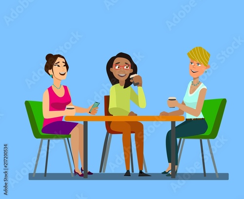 Three girls sitting at a table together talking to coffee break. photo