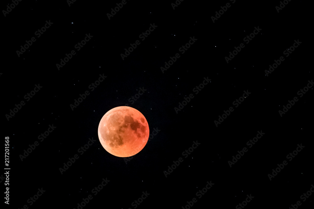 eclipsed red moon in a dark sky full of stars with planet mars
