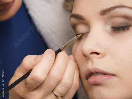 Woman getting eyes make up done by artist