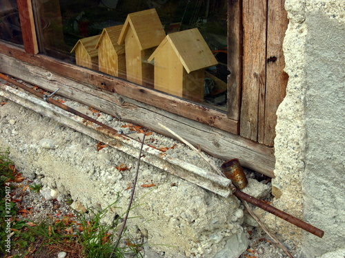Selbstgebastelte Holzhäuschen für Kinder hinter der Fensterscheibe einer alten Werkstatt auf einem Bauernhof in Rudersau bei Rottenbuch im Pfaffenwinkel im Kreis Weilheim-Schongau in Oberbayern