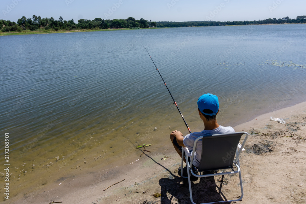 boy teenager is fishing on the fishing rod in summer. boy teenager is fishing on the fishing rod in summer.