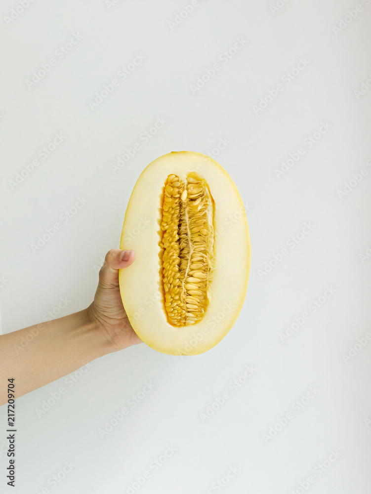 Melon Front view Girl is holding a half of ripe melon against white background Photo in minimalist style with copy space Melon Front view Girl is holding a half of ripe melon against white background Photo in minimalist style with copy space