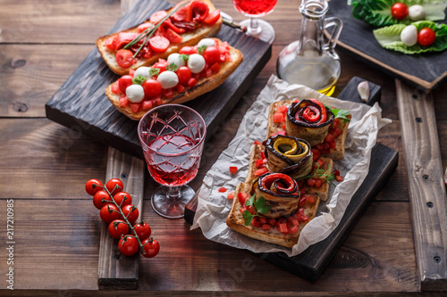 Bruschetta with tomato, basil and mozzarella cheese on wooden board. Traditional italian appetizer or snack, antipasto photo