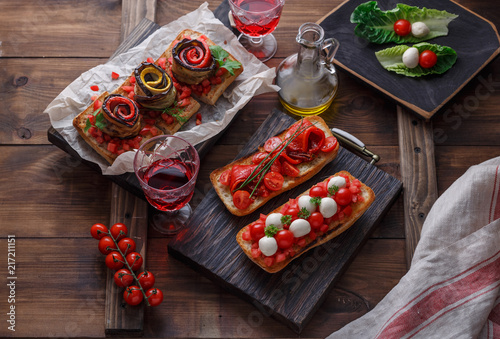 Bruschetta with tomato, basil and mozzarella cheese on wooden board. Traditional italian appetizer or snack, antipasto photo
