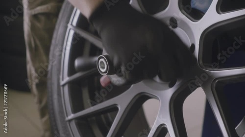 man balances the wheel after tire fitting