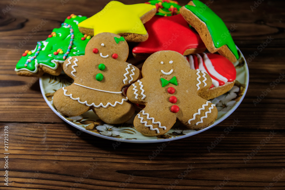 Plate with tasty festive Christmas gingerbread cookies on wooden table