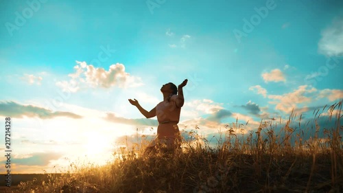 Girl folded her hands in prayer silhouette at sunset. woman lifestyle praying on her knees. slow motion video. Girl folded her hands in prayer pray to God. the girl praying asks forgiveness for sins photo