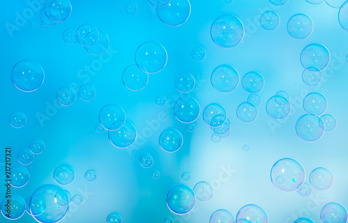 Radiant soap bubbles on blurred blue background. Rainbow soap bubble.