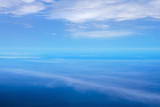 Aerial view with cloud ripples above the ocean and fluffy cloudscape