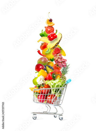 Fototapeta Naklejka Na Ścianę i Meble -  Fresh vegetables and fruits fly in a crowded shopping cart isolated on a white background. Mountain of fresh vegetables and fruits in a crowded shopping cart isolated on white background