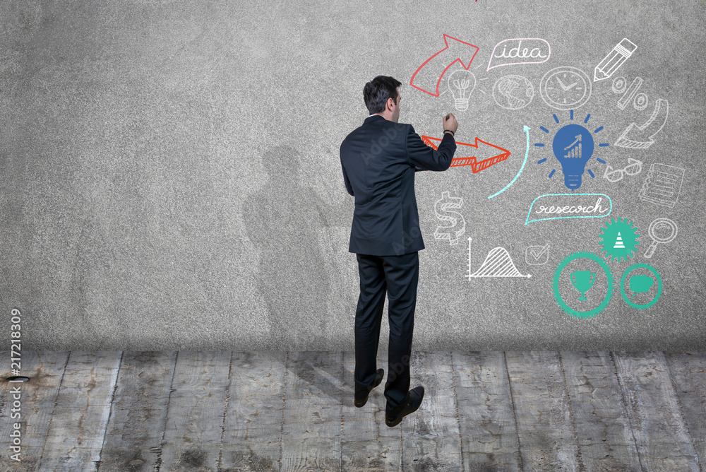Businessman drawing sketches and ideas on a wall Businessman drawing sketches and ideas on a wall