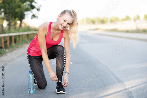 Sportliche junge Frau bindet ihre Laufschuhe 