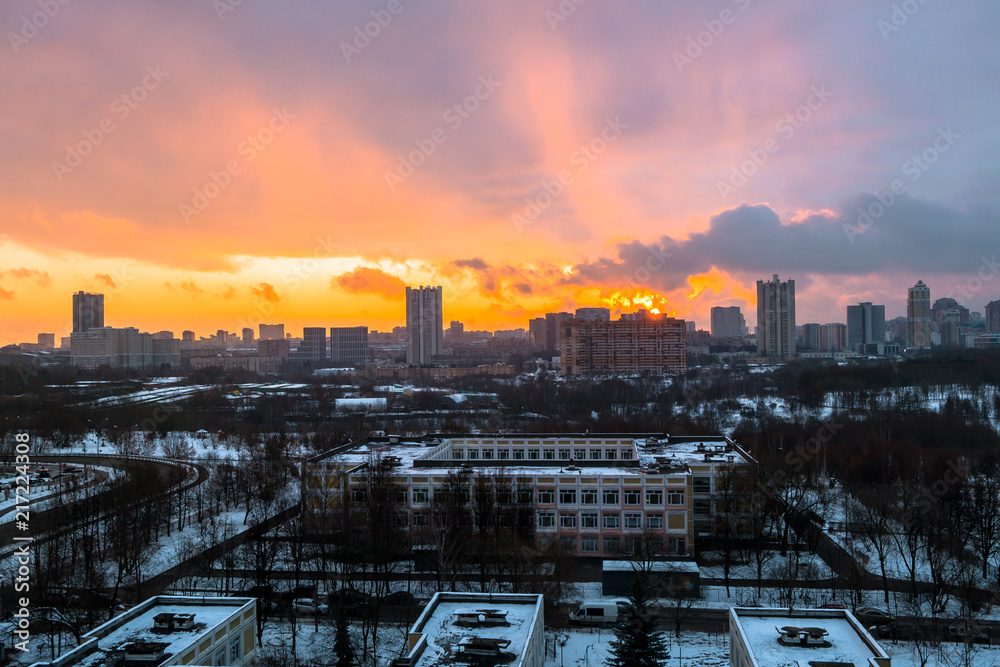 Winter fiery dawn over the city. Panoramic view of a modern residential area and a delightful sky in the background.