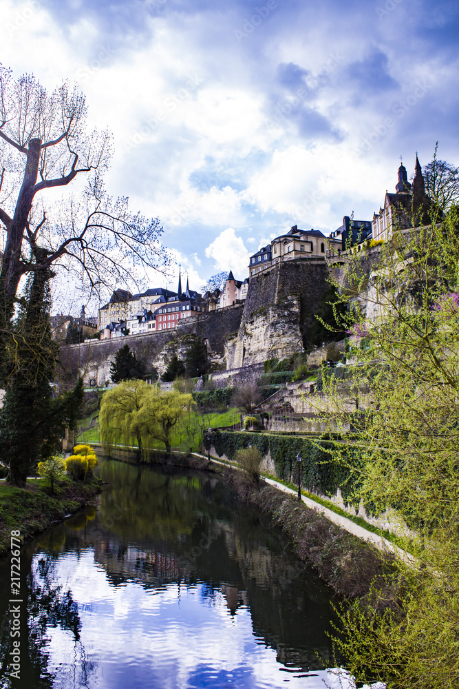 Looking Down the Alzette River Lined with Spring Trees and Flowers as It Flows through the Village of Grund in Luxembourg City, Luxembourg