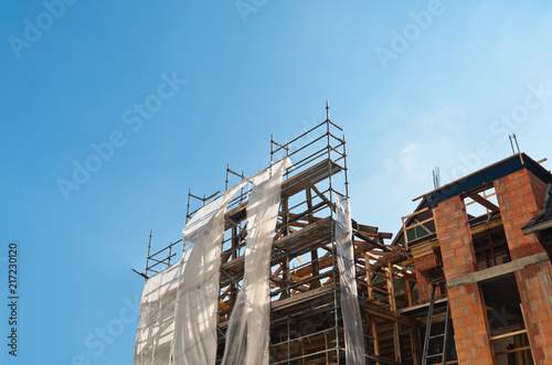 Sanierungsarbeiten an einem alten Gebäude und ein Baugerüst unter blauem Himmel © fefufoto