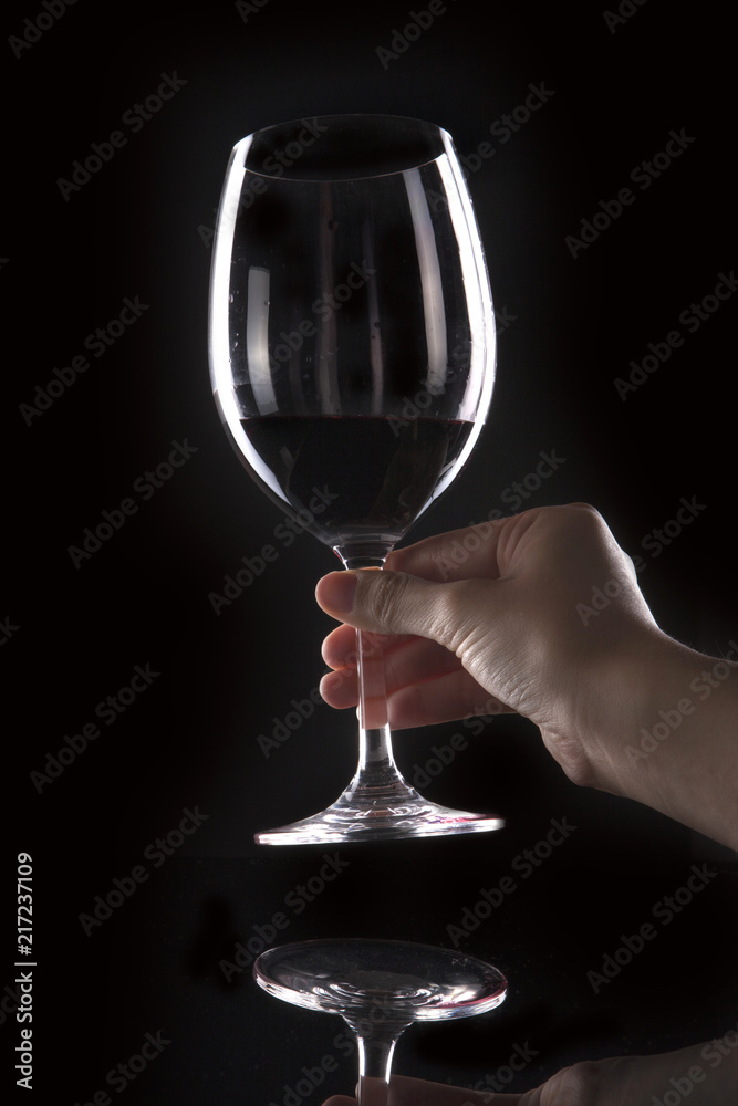 woman hand hold a glass on the black