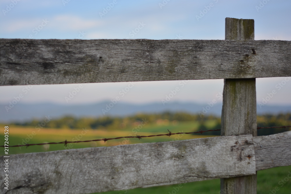 Fence line with mountain ridge at sunset