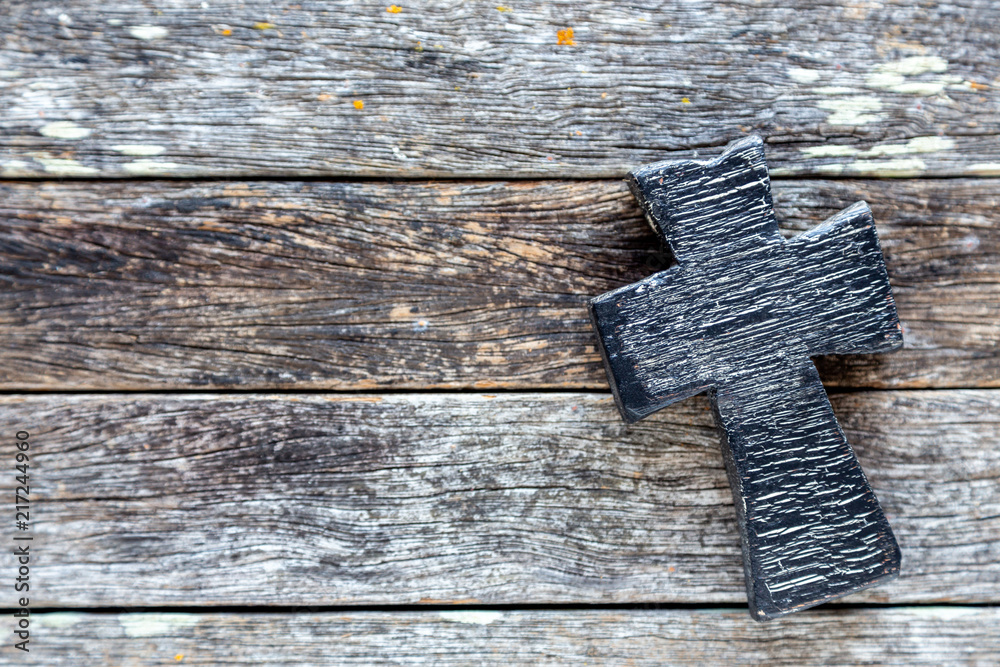 Black cross on weathered barn wood background