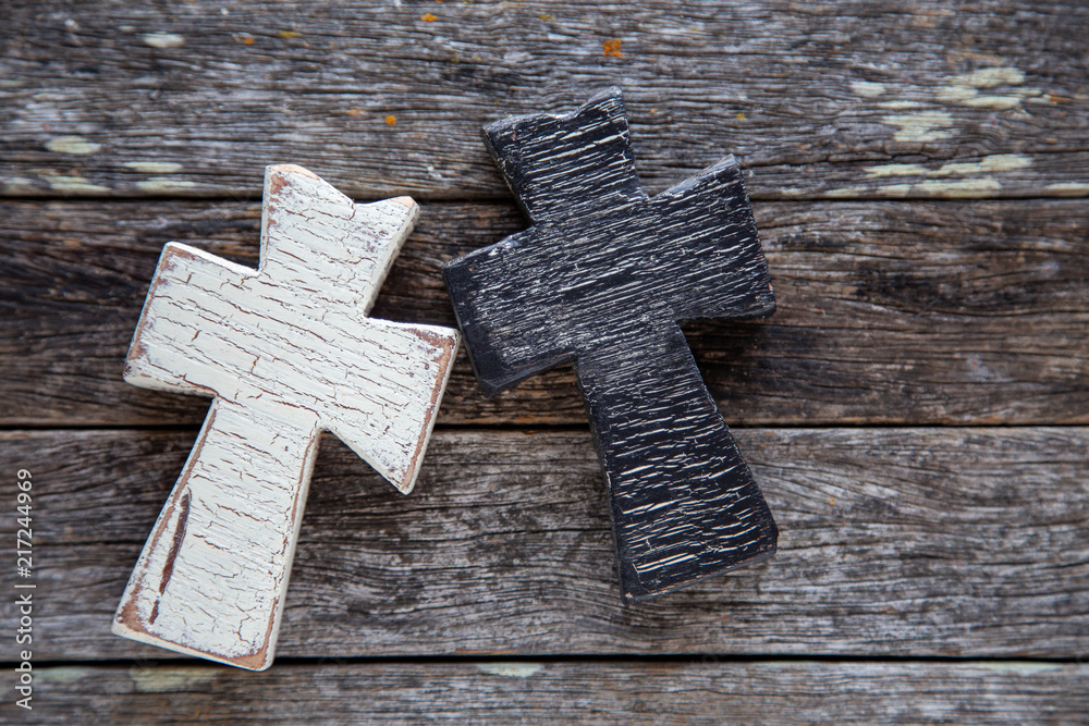 Black and white cross on wooden background
