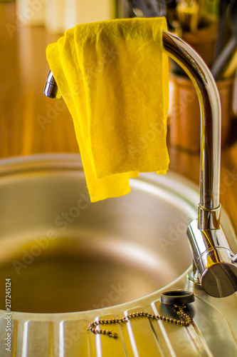 Cuadro en lienzo an unhygienic dishcloth hangs over a faucet to dry