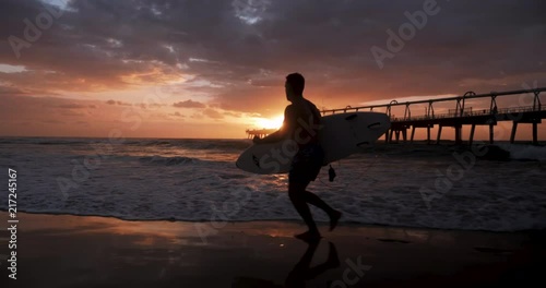 Young Male Surfer Running Sunrise Slow Motion photo