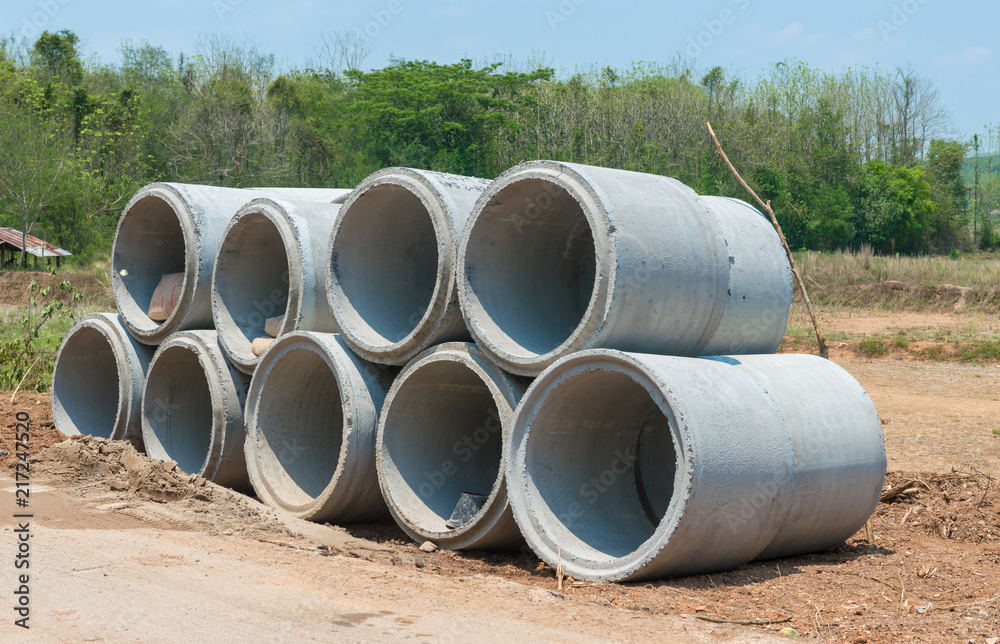 Pile of Concrete Drainage Pipe on a building Site .Concrete pipe stacked sewage water system aligned on construction site. Pile of Concrete Drainage Pipe on a building Site .Concrete pipe stacked sewage water system aligned on construction site.