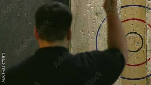Man Throwing Axe and Hitting Wood Target in Slow Motion